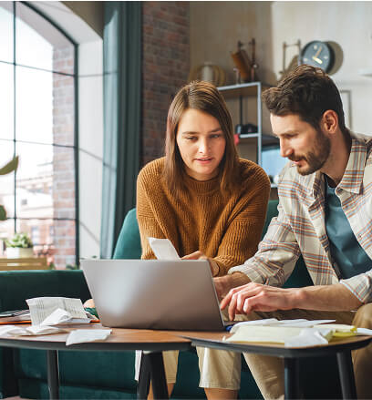 Man and woman working together on a laptop going through receipts