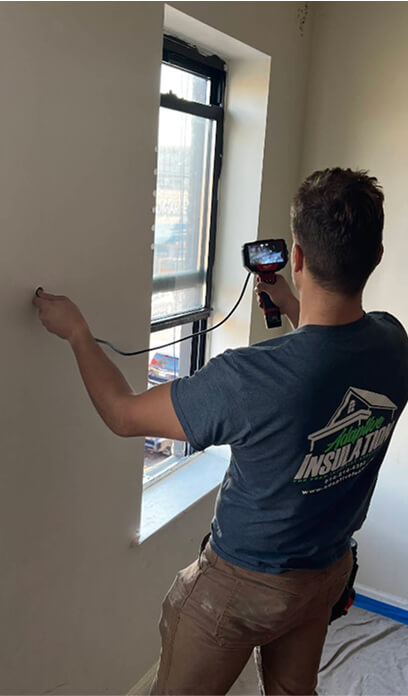 Man inside home testing indoor insulation efficiency