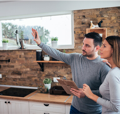Home owner couple standing in kitchen discussing home improvement